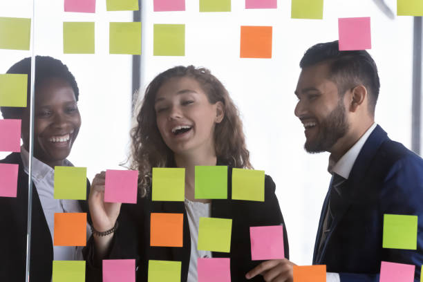 istock Cheerful multiethnic business group enjoying teamwork, filling notes 1424912466