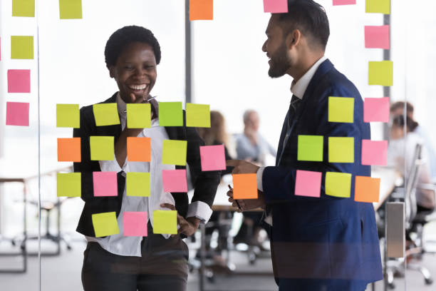 istock Cheerful diverse business team partners talking at glass board 1424912528
