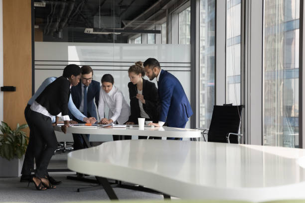 istock Serious diverse business group meeting at table in modern office 1424912669