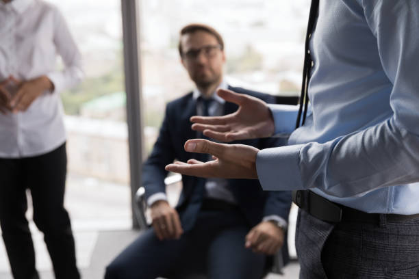 hand gesture of male business leader talking to employees - gesprek coaching detail stockfoto's en -beelden