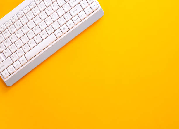 istock Modern white keyboard on yellow background, great design for any purpose. Flat PC symbol. Top view, copy space 1424918918