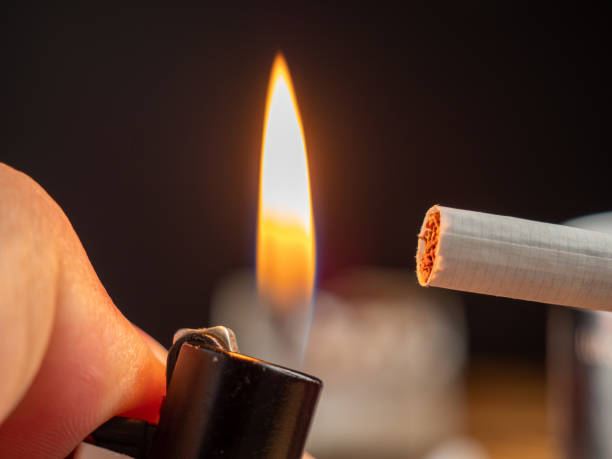 istock Lights a cigarette with a lighter. Smoking damages the lungs and kills. 1424919401