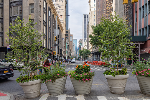 Broadway, Manhattan, New York, NY, USA - July 16th 2022: Broadway block with large potted plants at West 27th Street