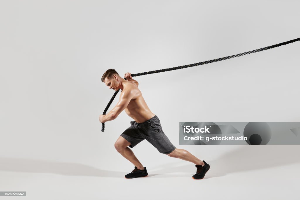 Person Pulling At Ropes Confident Young Man With Perfect Body Pulling A Rope Against White ...