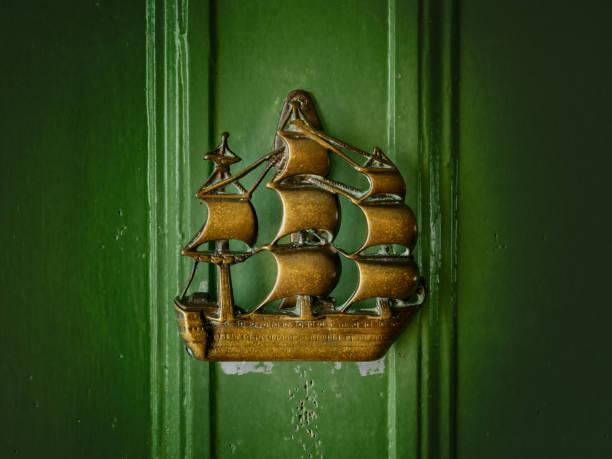 Detail of a copper door handle of a wooden door representing Poseidon and two seahorses