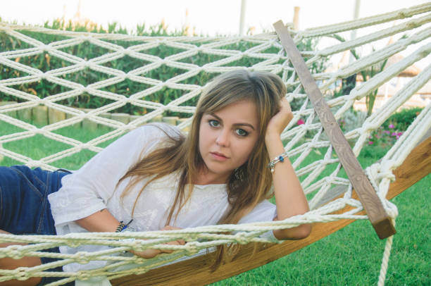 istock A young woman is resting in a white hammock. 1424927013