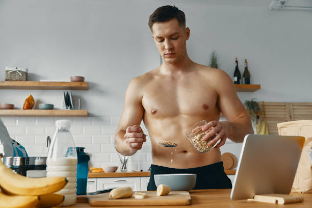 istock Handsome fit man preparing healthy food while standing at the kitchen 1424927131