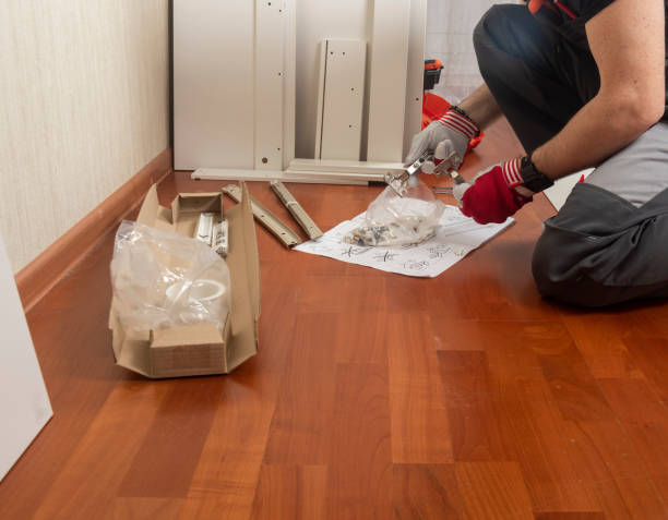 istock a man furniture assembler unpacks packages with metal hinges and screws for assembling a cabinet 1424930031