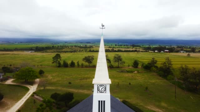 Drone shot of white Church out in country side between farms in George - 4k Resolution