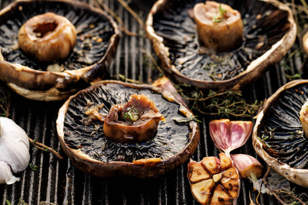 Cogumelos portobello grelhados com ervas e alho em um prato de grelhado - foto de acervo