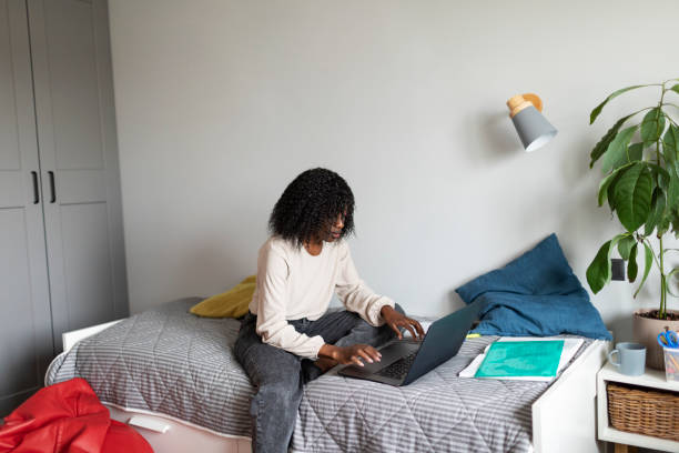 istock Young adult African woman learning at home using laptop 1424940182