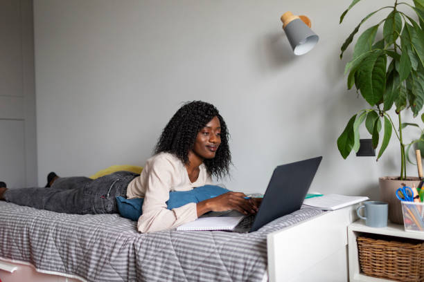 istock Young adult African woman learning at home using laptop 1424940185