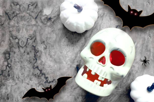 istock Halloween skull and decorations on gray background. Flat lay bats and skull. Halloween greeting card. 1424940227
