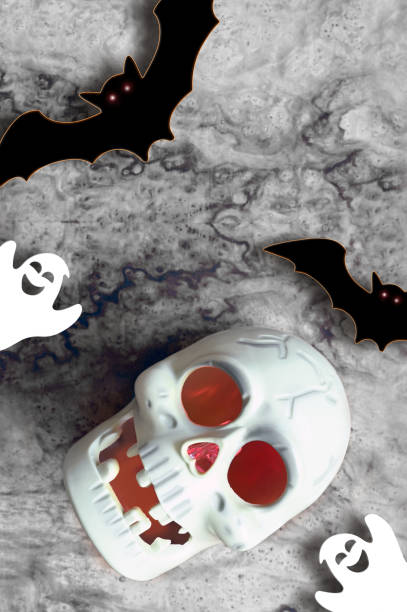 istock Halloween skull and decorations on gray background. Flat lay bats and skull. Halloween greeting card. 1424940285