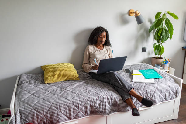 istock Young adult African woman learning at home using laptop 1424940314