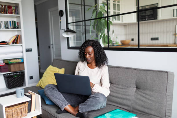 istock Young adult African woman learning at home using laptop 1424940384