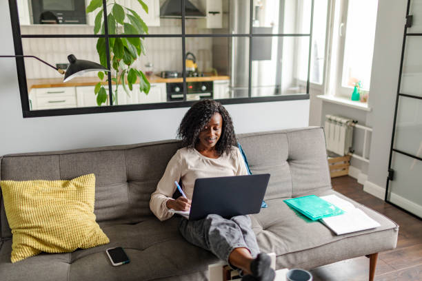 istock Young adult African woman learning at home using laptop 1424940539