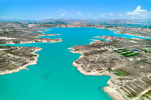 Drone point of view Embalse de La Pedrera large turquoise colored lake used as source of water supply, no people, sunny summer day, bright colors. Orihuela, Costa Blanca, Spain