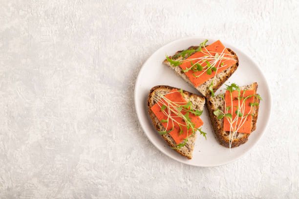 istock Grain bread sandwiches with red tomato cheese and microgreen on gray,  top view, copy space. 1424945852