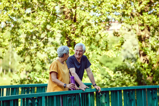 istock Older couple enjoy morning stroll in summer park 1424946128