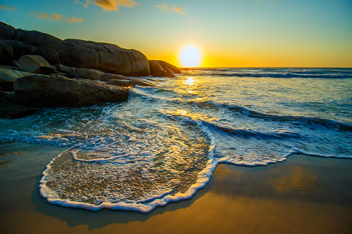 Beautiful sunset shot of empty beach with long shadows of rolling wave, an empty beach with sun, sea, rocks and beach, no need to scroll further as your inspirational quote is ready to be added