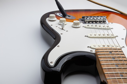 Close-up of the body of a vintage electric guitar, with the pickguard and pickups being upgraded.