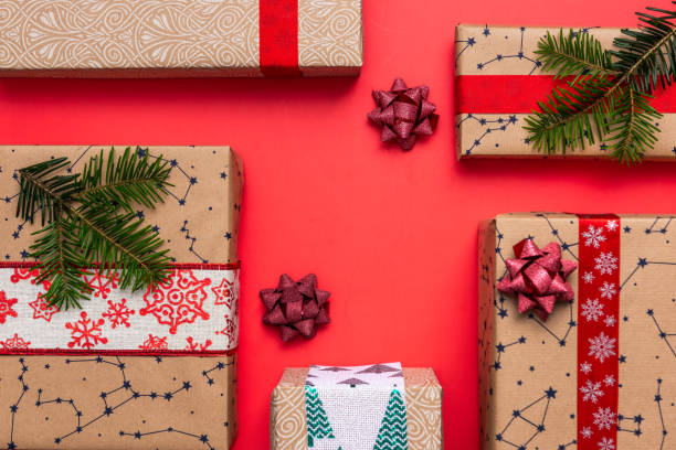 istock Christmas gifts in boxes on red festive background, flat lay 1424947513