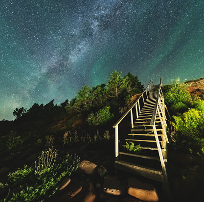 A rustic set of stairs leads to the sky. Long exposure.