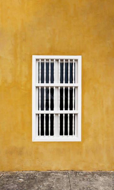 istock Yellow colorful wall with a white window in caribbean house. 1424965678