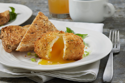 Crispy Deep Fried Soft Boiled Eggs with Panko Breadcrumbs and Whole Grain Toast, Coffee and Apple Juice