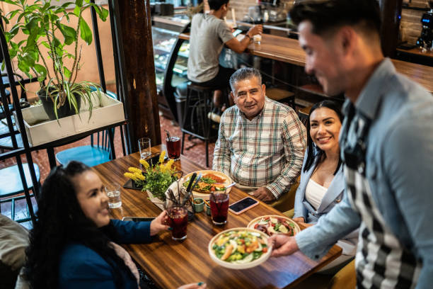 istock Waiter serving a finished dish to costumers in a restaurant 1424971828