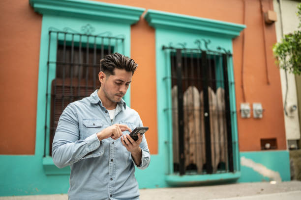 istock Mid adult man using mobile phone outdoors 1424971894