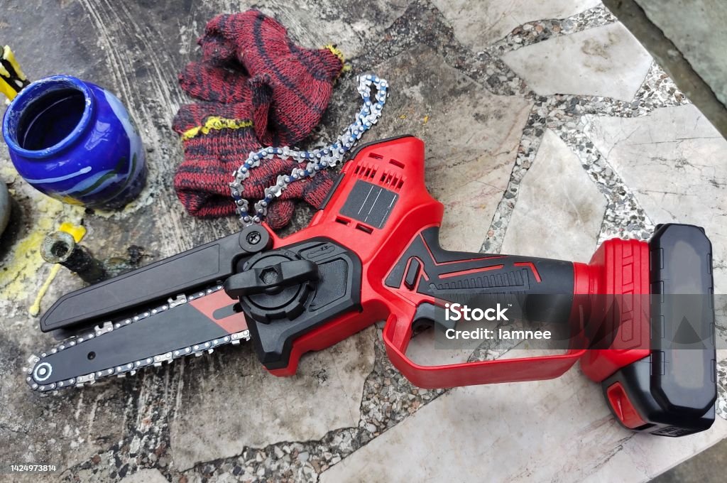 Cordless Mini Electric Chainsaw Cordless Mini Electric Chainsaw Used in Small Tree Felling, Limbing or Pruning. Battery Stock Photo