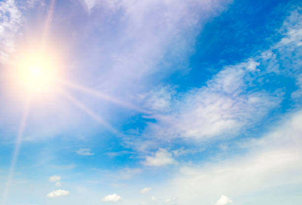 istock Blue sky with fluffy clouds and bright sun as a background 1424975451