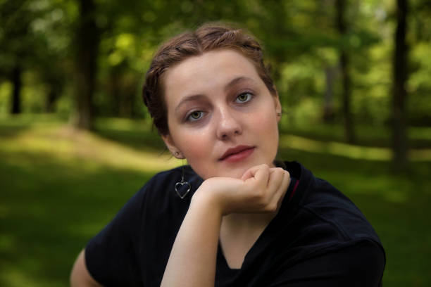 young woman thinking leaning on her chin outside student portrait