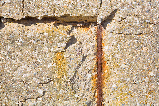 Old reinforced concrete wall without concrete cover due oxidation with damaged and rusty metallic reinforcement