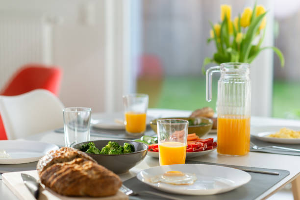 Breakfast closeup with eggs, wholegrain bread, green fresh broccoli, and orange juice