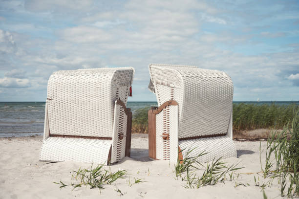 Romantic sea scene at white beach with beach chair at summer sunny day in north Germany stock photo