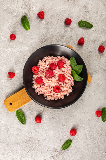 Delicious rice pudding with raspberry and mint leaf. stock photo