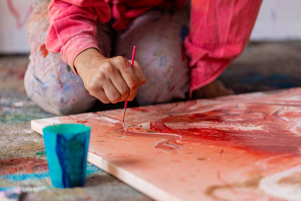 Hand of an artist painting with paintbrush.