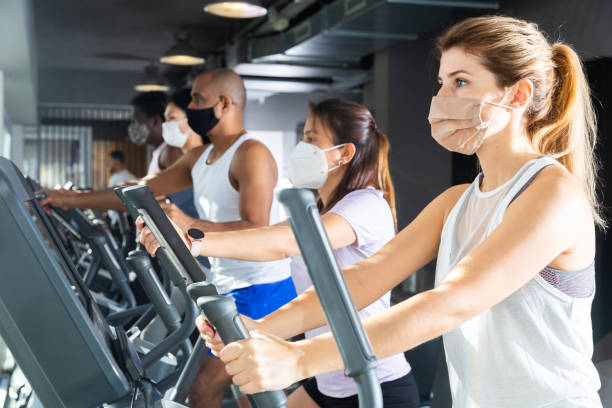 istock Woman training on elliptical trainer in gym 1424982377