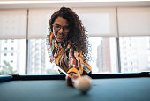 Young woman playing snooker at the office