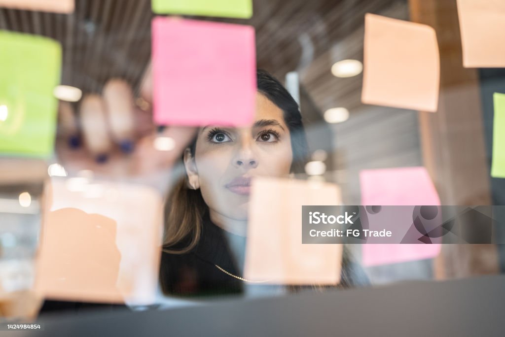 Wanita muda menulis di pos di kantor - Bebas Royalti Aspirasi - Konsep Foto Stok Wanita muda menulis di pos di kantor - Bebas Royalti Aspirasi - Konsep Foto Stok