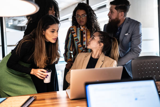 istock Coworkers doing a meeting using laptop and talking at the office 1424985076