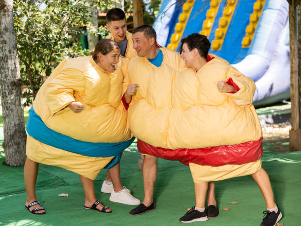 homens e mulheres em trajes de sumô lutando em parque de diversões ao ar livre - sumo - fotografias e filmes do acervo
