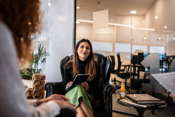 giovane donna in una riunione con i colleghi in ufficio - recruiter foto e immagini stock