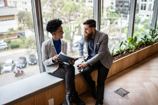 istock Coworkers talking at the office 1424987863