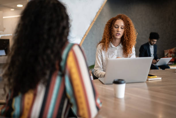istock Coworkers talking in the office 1424987878