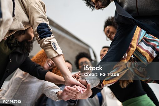 istock Coworkers with stacked hands at the office 1424987910