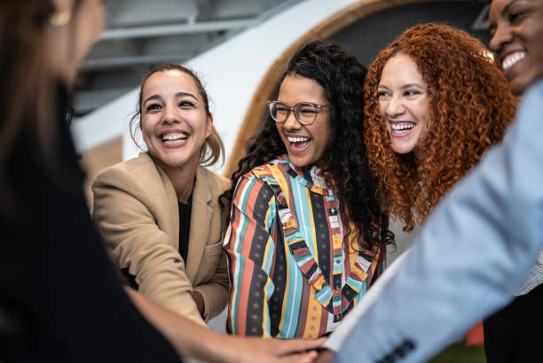 коллеги со сложенными руками в офисе - pride ethnic women office стоковые фото и изображения